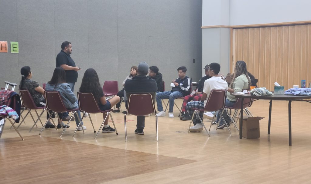 group of people sitting in a circle in chairs