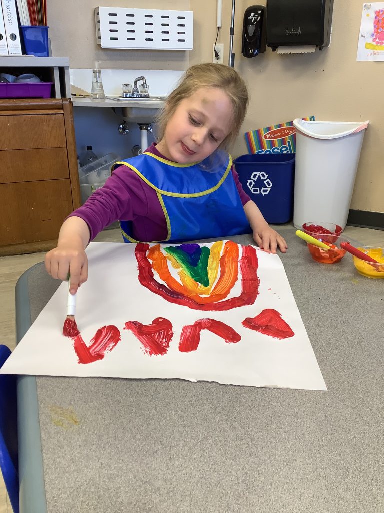 young girl painting a rainbow
