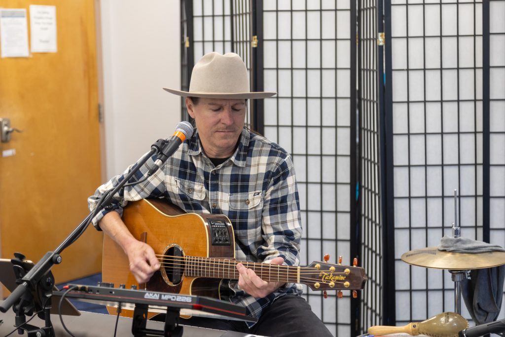 man playing guitar with microphone