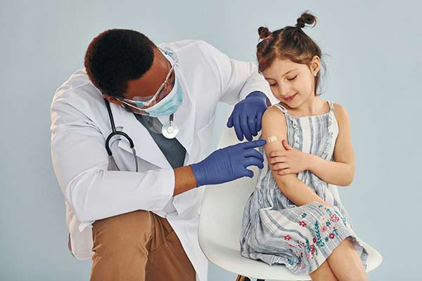 Male doctor giving a vaccination to a child patient
